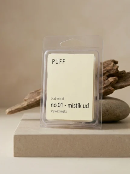 PUFF No.01 Mistik Ud ud ağacı kokulu soya wax melts ürünü, doğal taş ve odun detayları eşliğinde minimalist arka planda sergilenmiş.