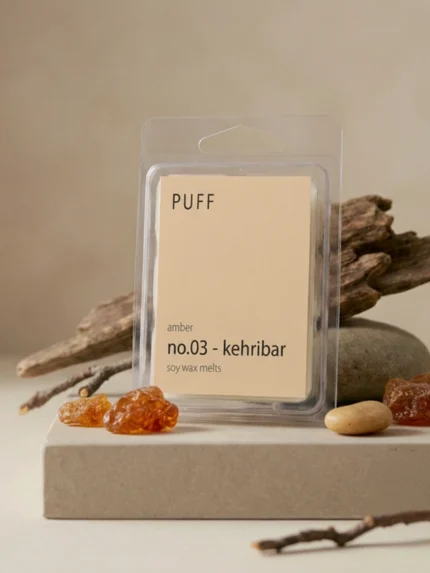 PUFF No.03 Kehribar amber kokulu soya wax melts ürünü, doğal taş ve reçine detayları eşliğinde minimalist arka planda sergilenmiş.